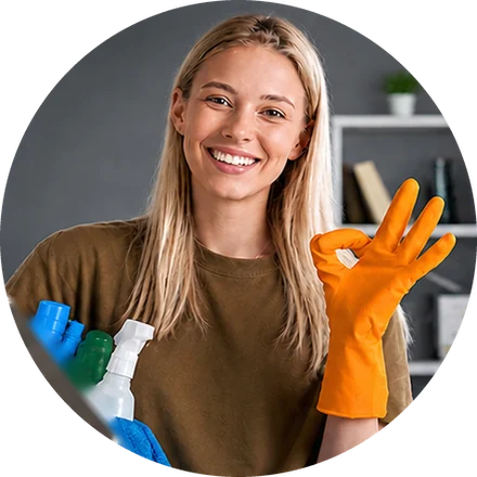 Colaboradora sonriente con guantes y productos de limpieza
